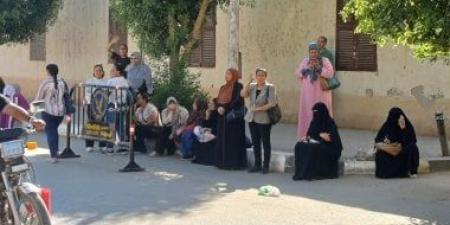 أولياء الأمور ينتظرون أمام لجان الثانوية العامة بأسوان بالدعاء وقراءة القرآن.. صور