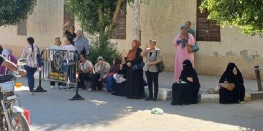 أولياء الأمور ينتظرون أمام لجان الثانوية العامة بأسوان بالدعاء وقراءة القرآن.. صور